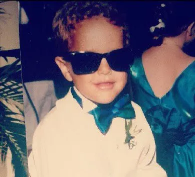 A much younger David at a wedding, in a white shirt and teal bow tie — and sunglasses.